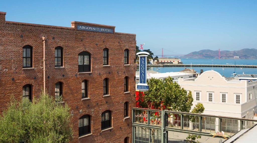 Backsteinfassade des Argonaut Hotels mit Hafen und Bucht im Hintergrund
