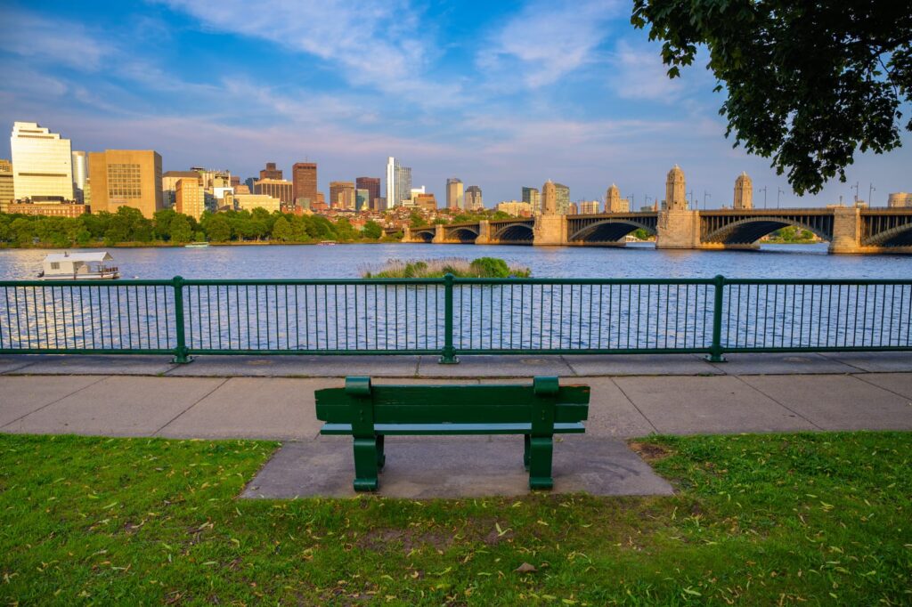 Bank am Charles River mit Bostons Skyline und einer Brücke im Hintergrund