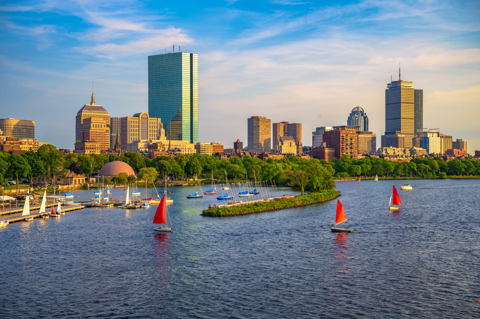 Segelboote auf dem Charles River vor Bostons Skyline und Bäumen am Ufer