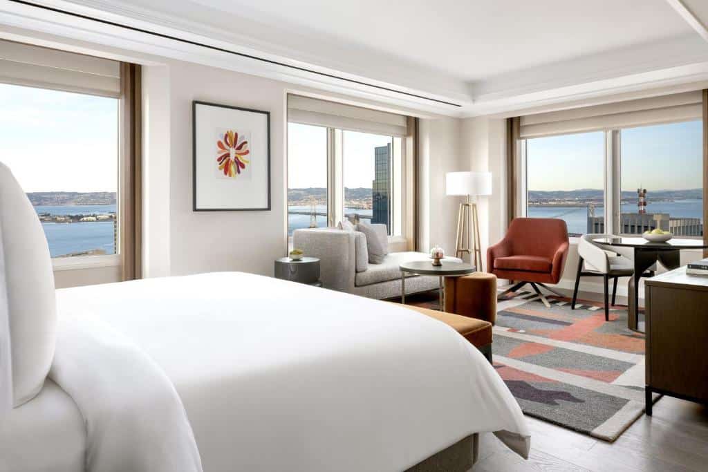 Schlafzimmer und Sitzbereich mit großen Fenstern im Four Seasons Hotel San Francisco at Embarcadero