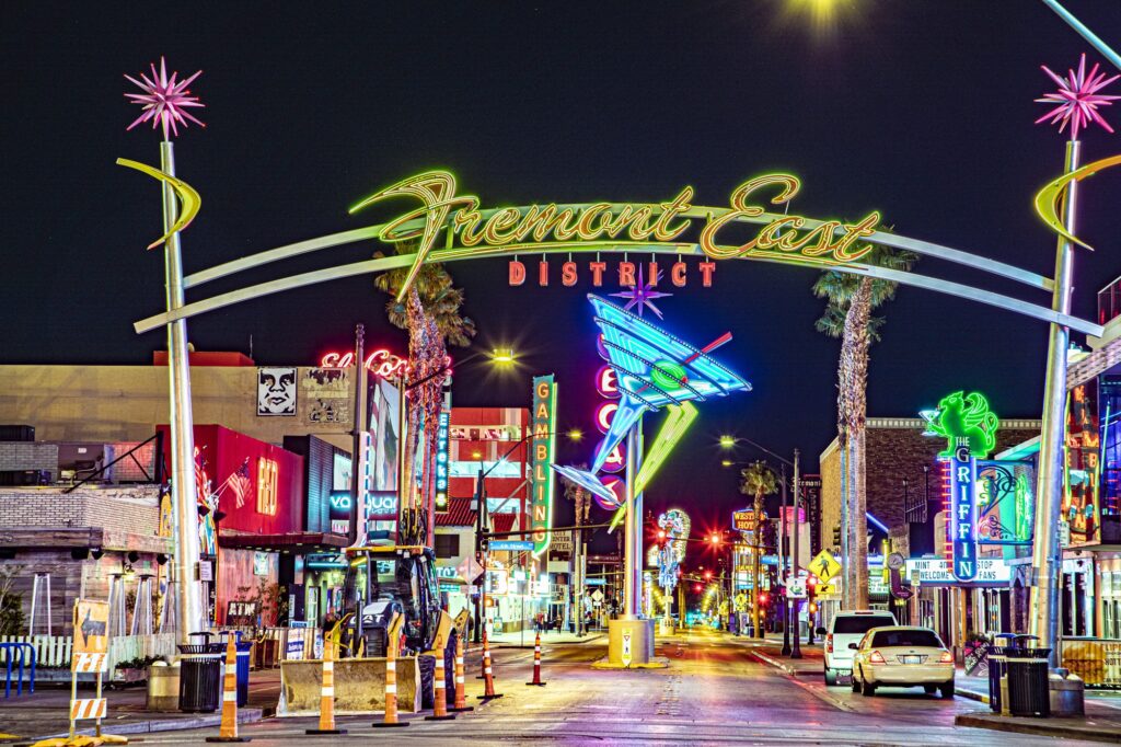 Beleuchteter Bogen des Fremont East District über einer Straße mit Neonschildern bei Nacht