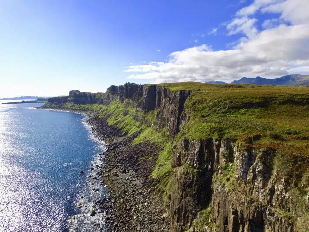 Hohe Küstenklippen und ein Wasserfall am Kilt Rock auf der Isle of Skye