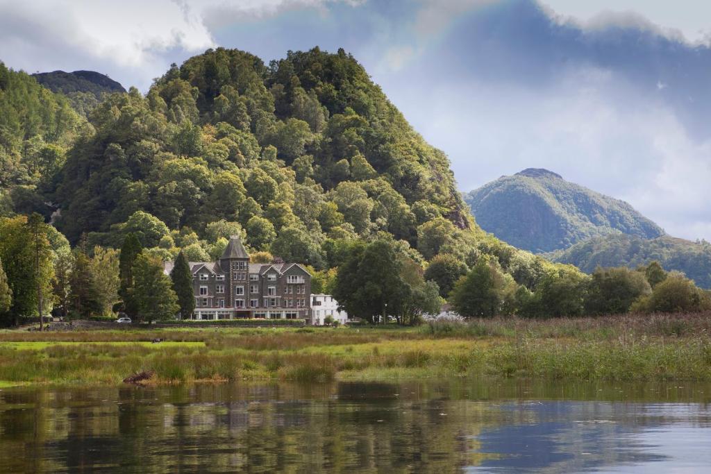 Spiegelung des Lodore Falls Hotels im Wasser am Derwentwater mit Wald im Hintergrund