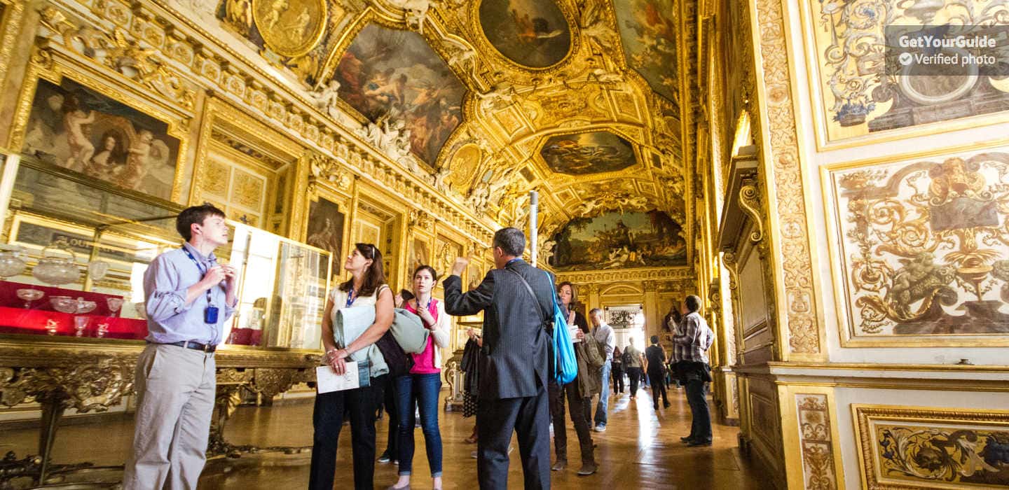 Prunkvoller Saal im Louvre Besucher in einem reich verzierten Saal des Louvre