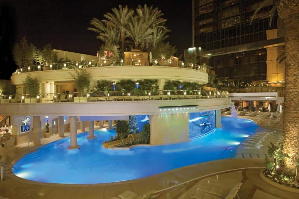 Blau beleuchteter Pool des Golden Nugget mit Palmen und Terrassen bei Nacht