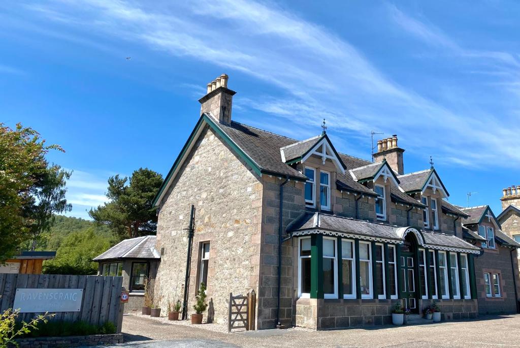 Steinfassade des Ravenscraig Guest House unter blauem Himmel in Aviemore