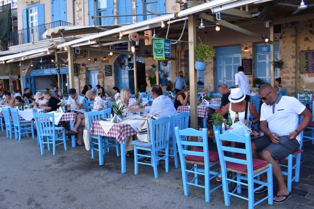 Tische eines Restaurants direkt am Hafen von Chania