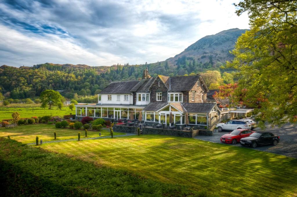 The Grand at Grasmere mit Rasen und Bäumen unterhalb der umliegenden Hügel
