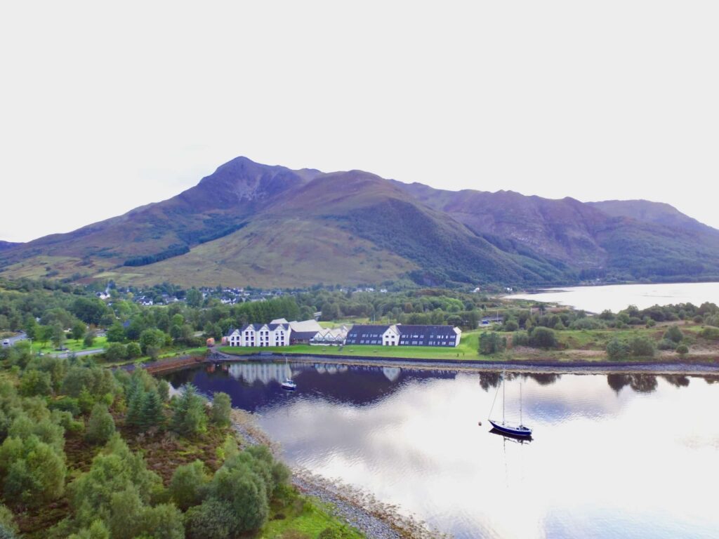 The Isles of Glencoe Hotel am ruhigen Wasser mit Bergen im Hintergrund