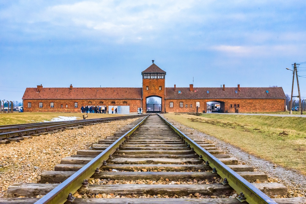 Das Torgebäude und die Bahngleise in Auschwitz-Birkenau, vom Inneren des Lagers aus gesehen