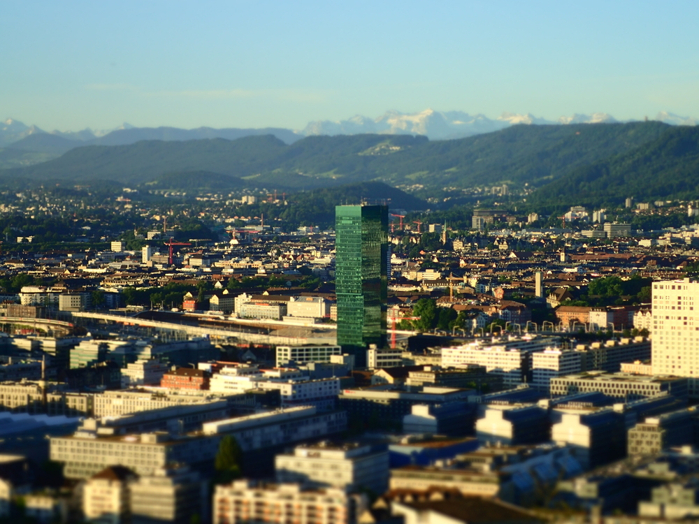 Der Prime Tower in Zürich West bei Sonnenaufgang mit den Alpen im Hintergrund