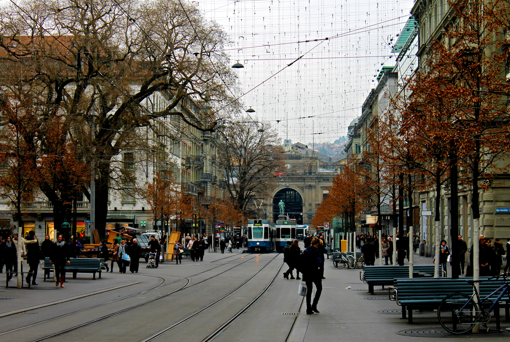 Die Bahnhofstrasse in Zürich mit Tramschienen und Fußgängern und dem Hauptbahnhof am Ende der Straße