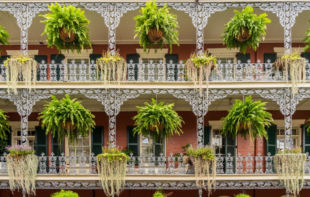 Haus mit schmiedeeisernen Balkonen und Blumenampeln an der Royal Street im French Quarter