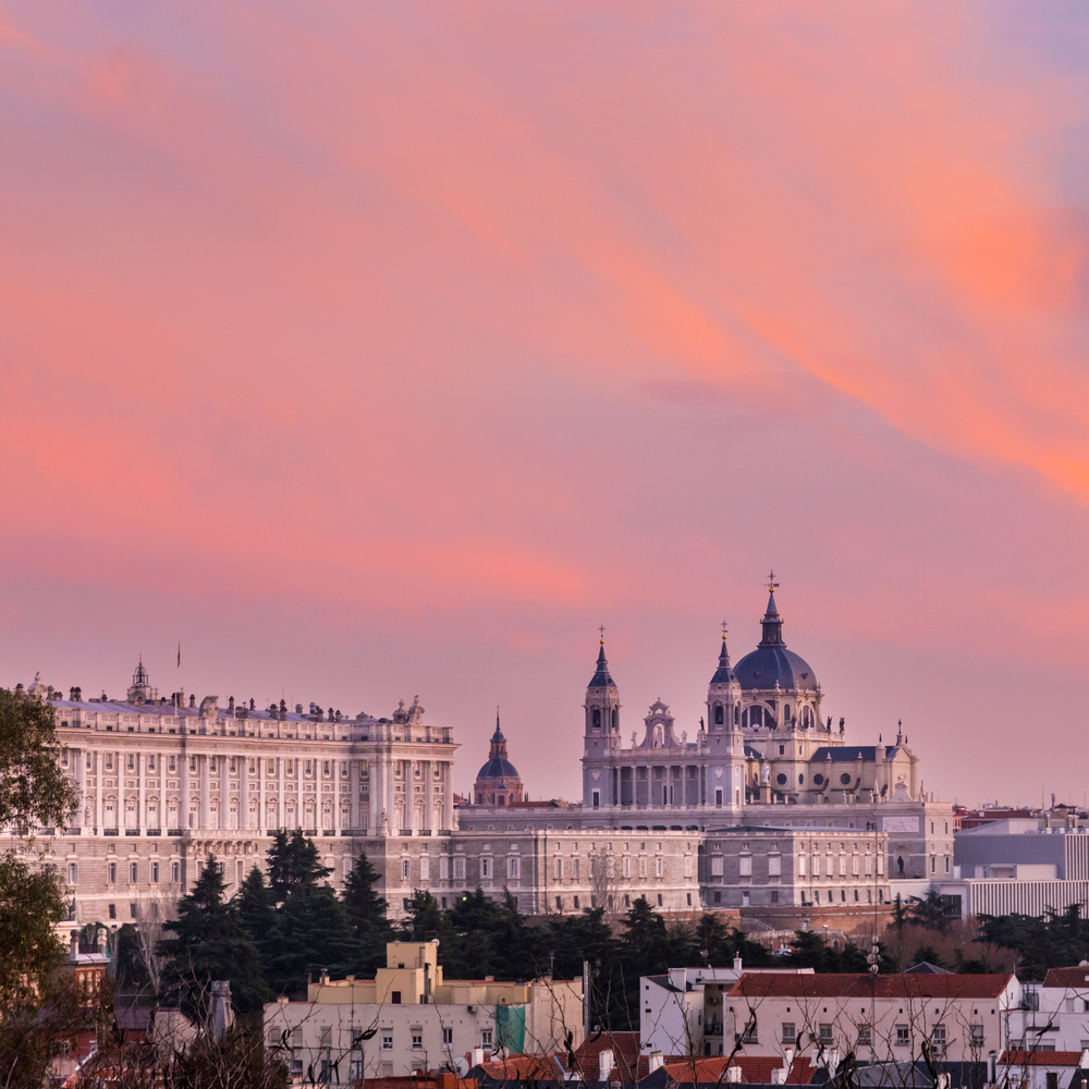 Die Skyline von Madrid mit der Almudena-Kathedrale und dem Palacio Real bei Sonnenuntergang