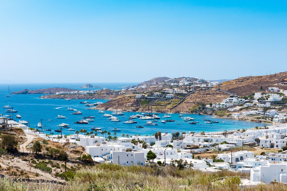 Sonnenliegen und Sonnenschirme am Strand von Ornos auf Mykonos