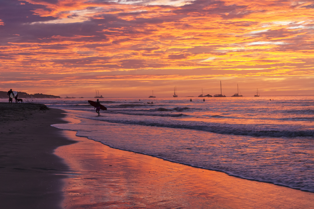 Surfer am Strand von Tamarindo in Guanacaste bei Sonnenuntergang