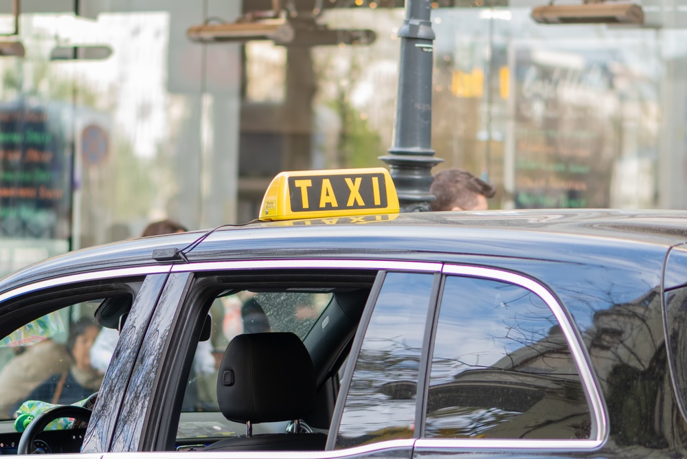Taxi mit gelbem Taxischild auf einer Wiener Straße