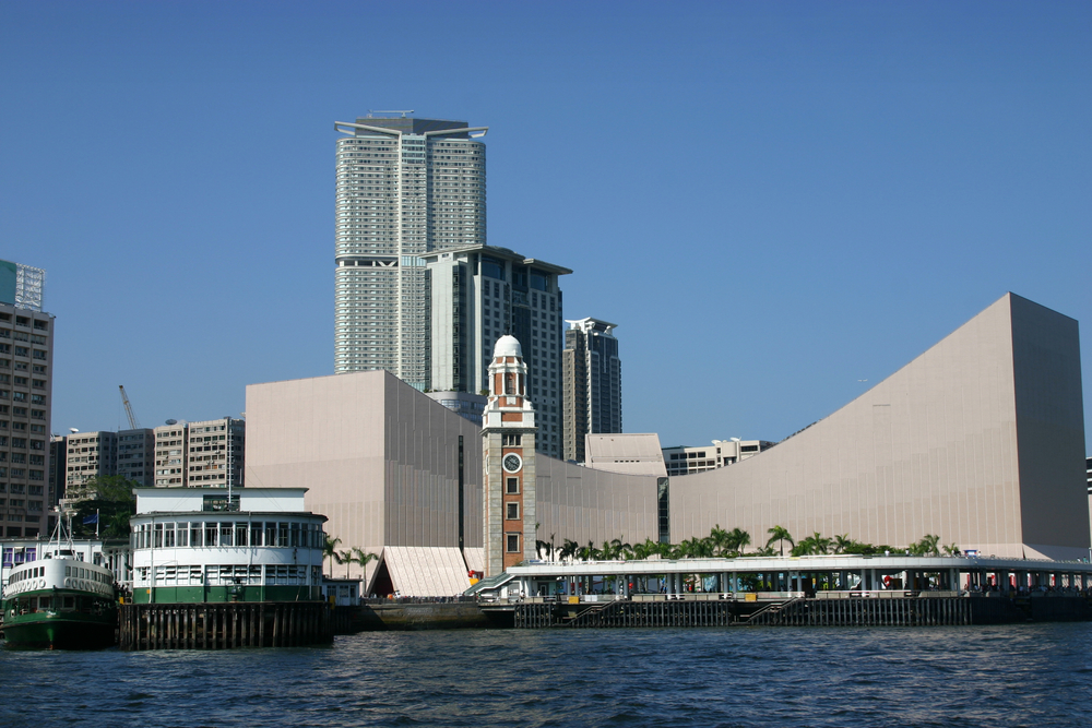 Tsim Sha Tsui vom Victoria Harbour aus gesehen mit Uhrturm und Fährterminal