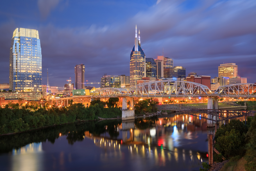 Die Skyline von Nashville und die Fußgängerbrücke John Seigenthaler Pedestrian Bridge über dem Cumberland River im Morgengrauen