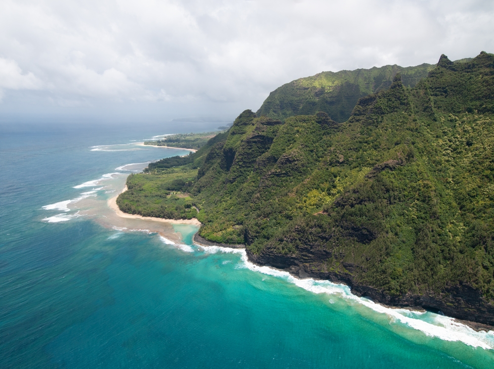 Luftaufnahme der Na-Pali-Küste auf Kauai mit steilen grünen Klippen und türkisfarbenem Meer