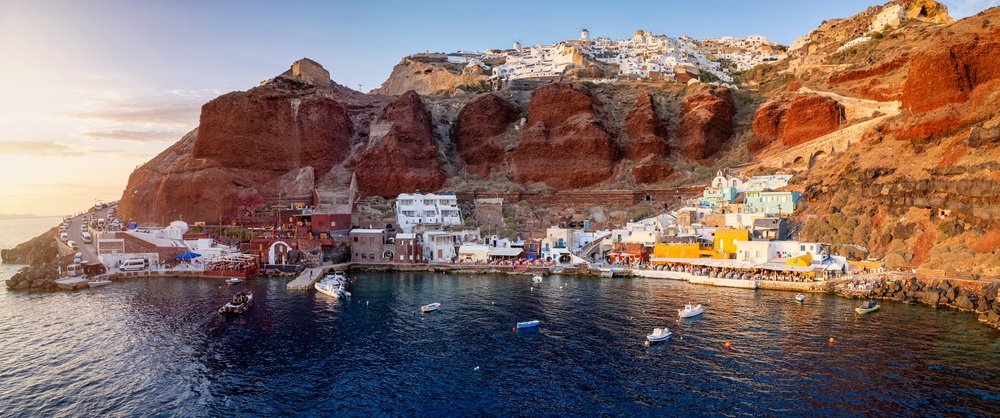 Ammoudi Bay mit Restaurants und Fischerbooten im Licht des Sonnenuntergangs