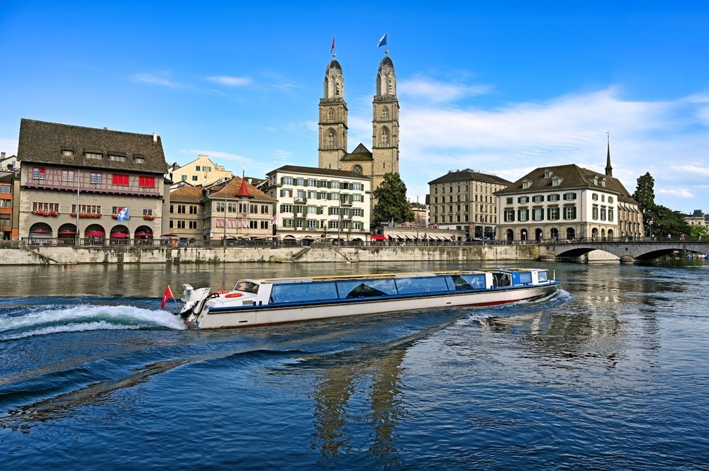 Ausflugsboot auf der Limmat in Zürich mit dem Grossmünster im Hintergrund