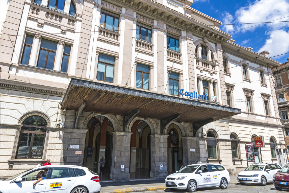 Fassade des Bahnhofs von Cagliari mit Taxis vor dem Eingang