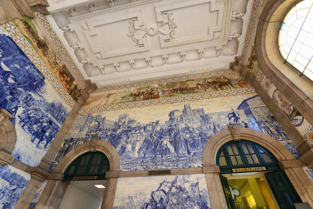 Blaue und weiße Azulejo-Fliesen an den Wänden der Haupthalle im Bahnhof São Bento in Porto