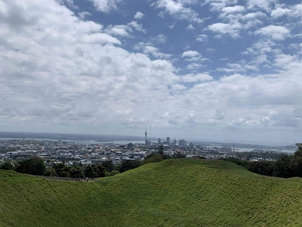 Blick vom Vulkan Mount Eden über Auckland mit dem Sky Tower im Hintergrund