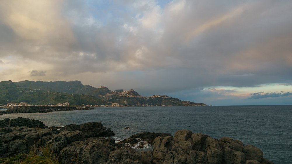 Die Bucht von Giardini Naxos mit Blick auf das Capo Taormina bei Sonnenuntergang