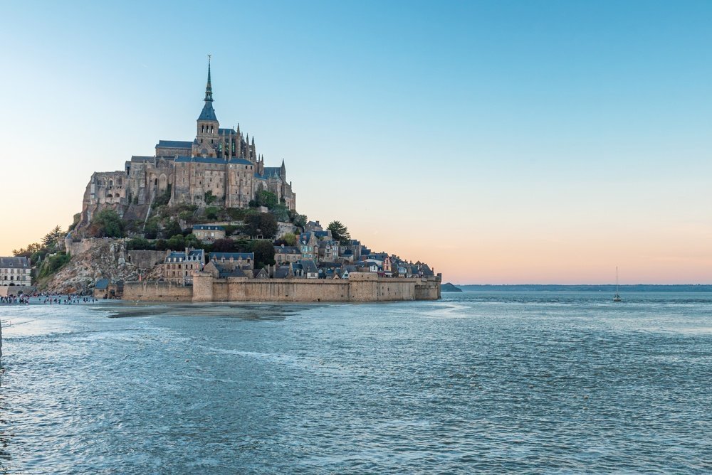 Mont-Saint-Michel bei Flut im Sonnenuntergang vom Wasser umgeben