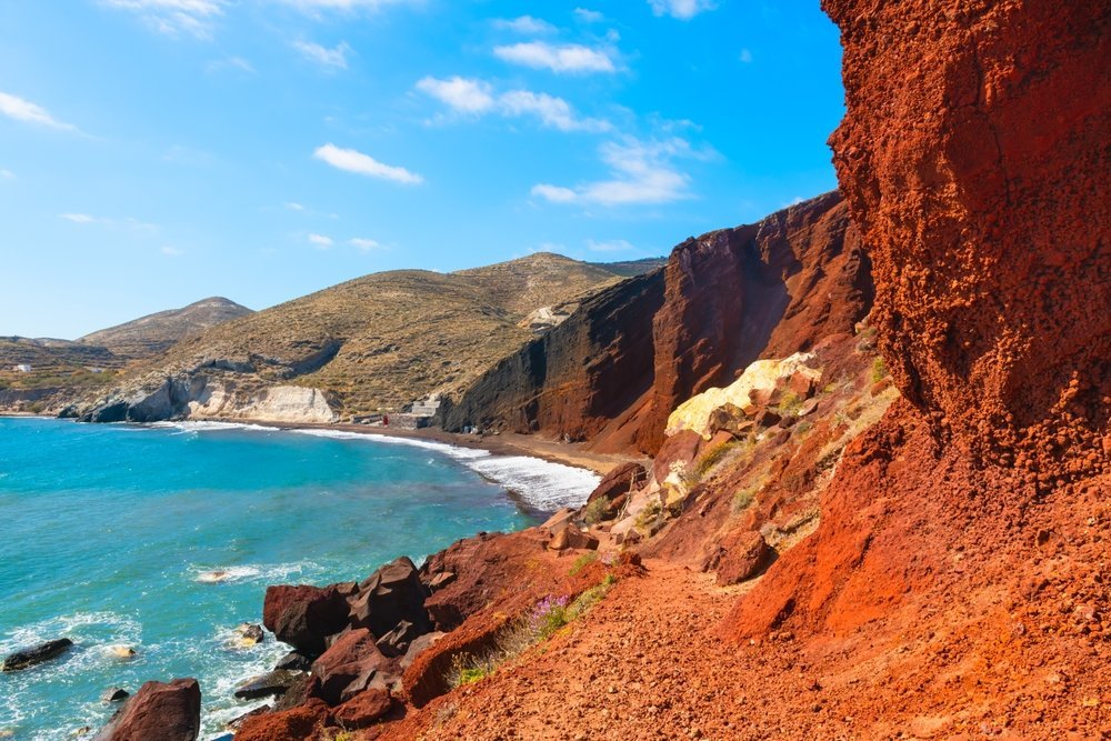 Roter Strand mit roten Vulkanfelsen und blauem Meer