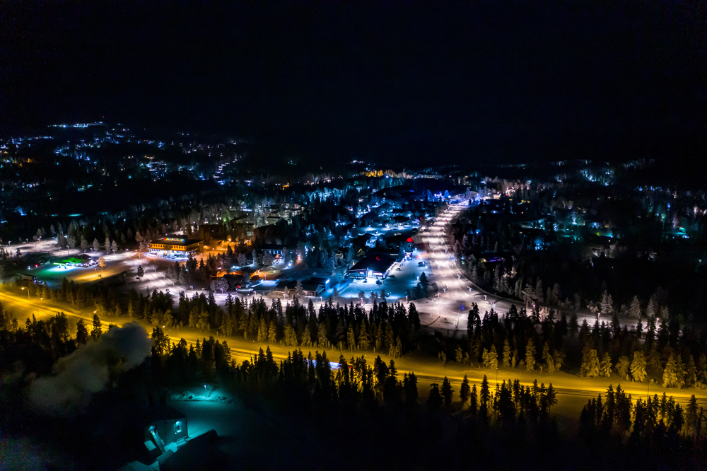 Luftaufnahme von Saariselkä am Abend mit bunten Lichtern in Lappland