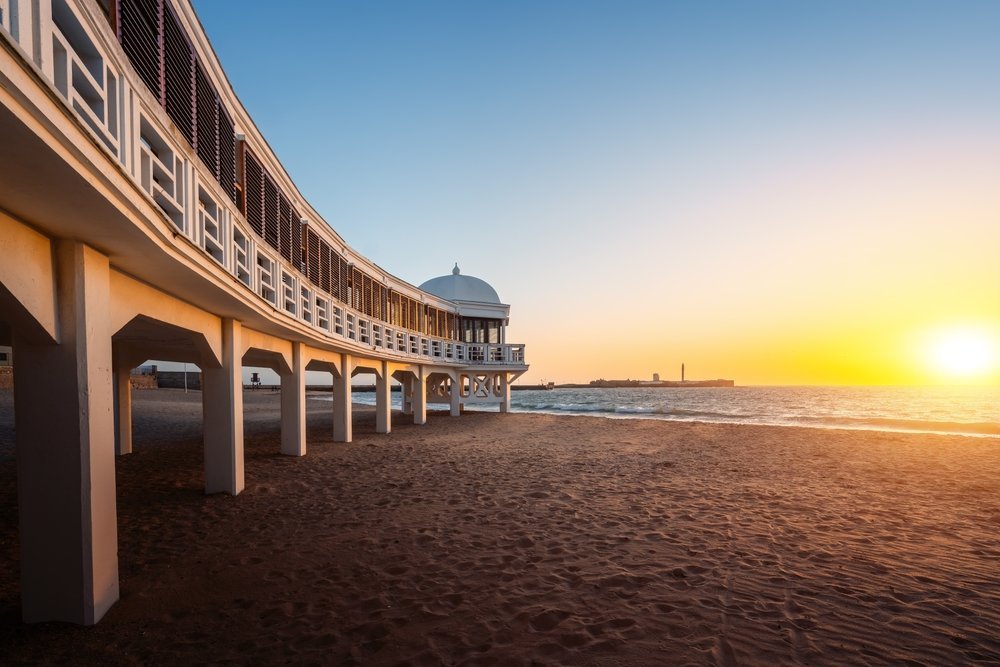 Der Strand La Caleta in Cádiz mit dem Badehaus Balneario de la Palma bei Sonnenuntergang