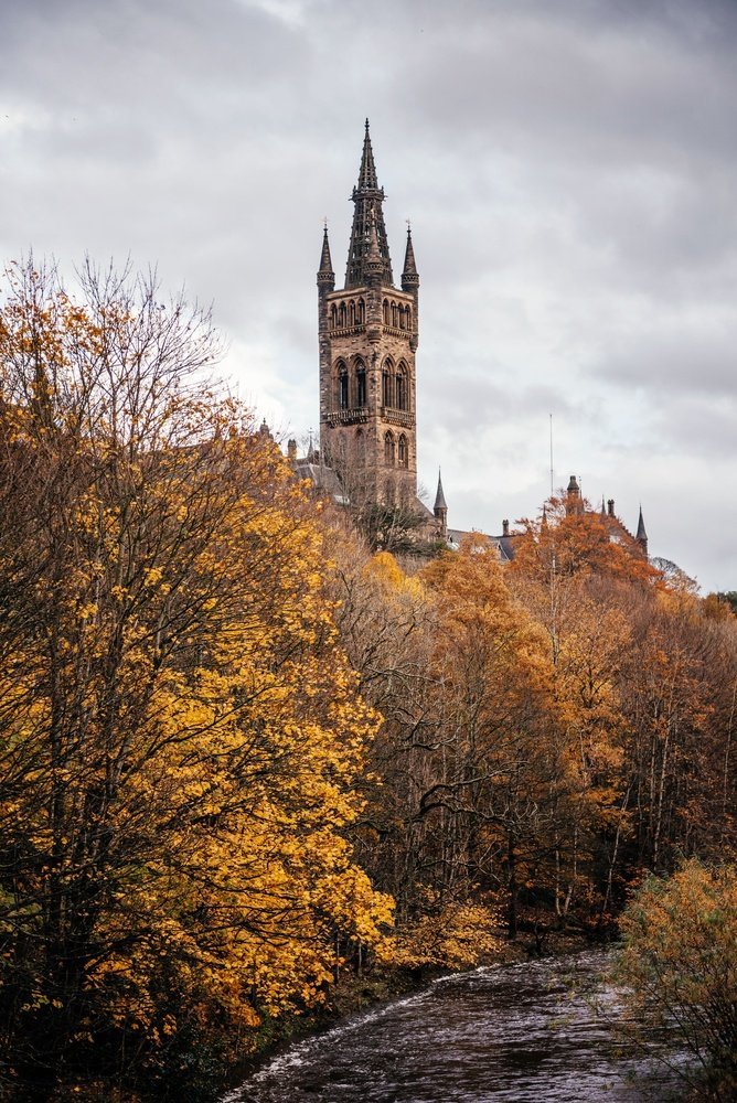 Der Turm der University of Glasgow über den Bäumen am Fluss Kelvin