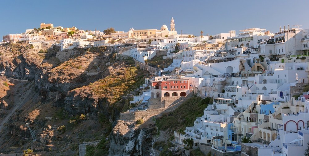 weiße Gebäude und Kirchen auf der Klippe in Fira