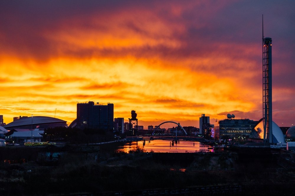 Die Skyline von Glasgow bei Sonnenuntergang, vom Fluss Clyde aus gesehen